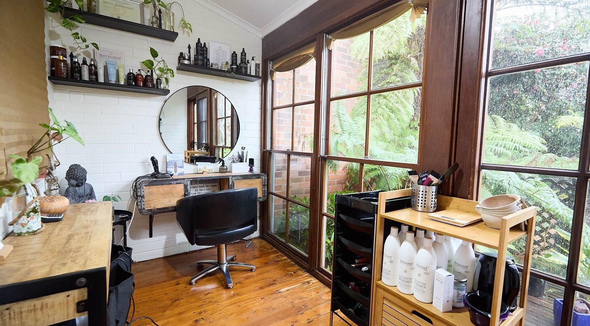 Bright, nature-inspired corner at Océane Hair Studio in Sydney, New South Wales, AU with hair products and mirror.