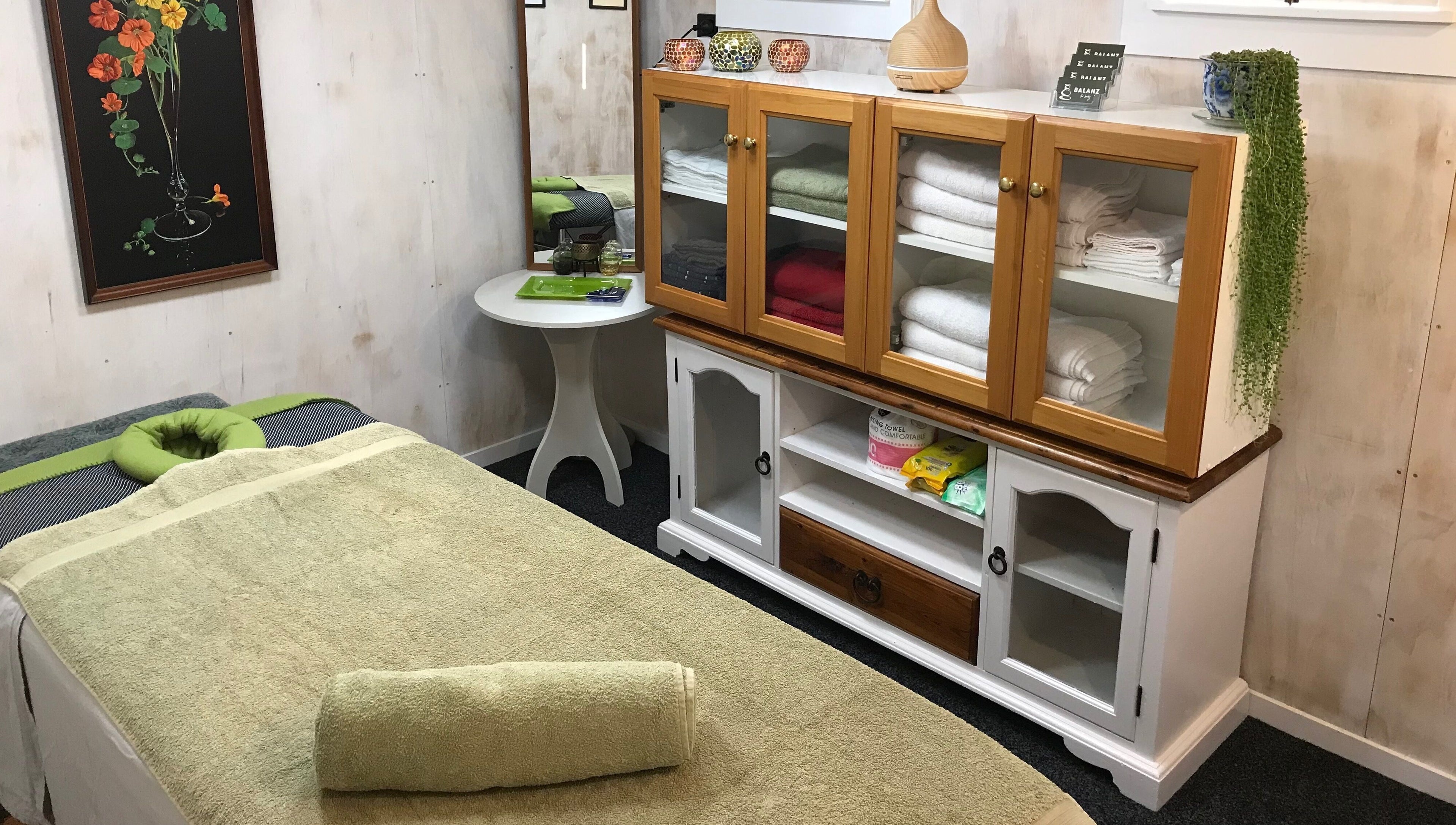 Relaxing massage room at Balanz for Body, Auckland, Auckland, NZ with cozy table and neatly stacked towels.