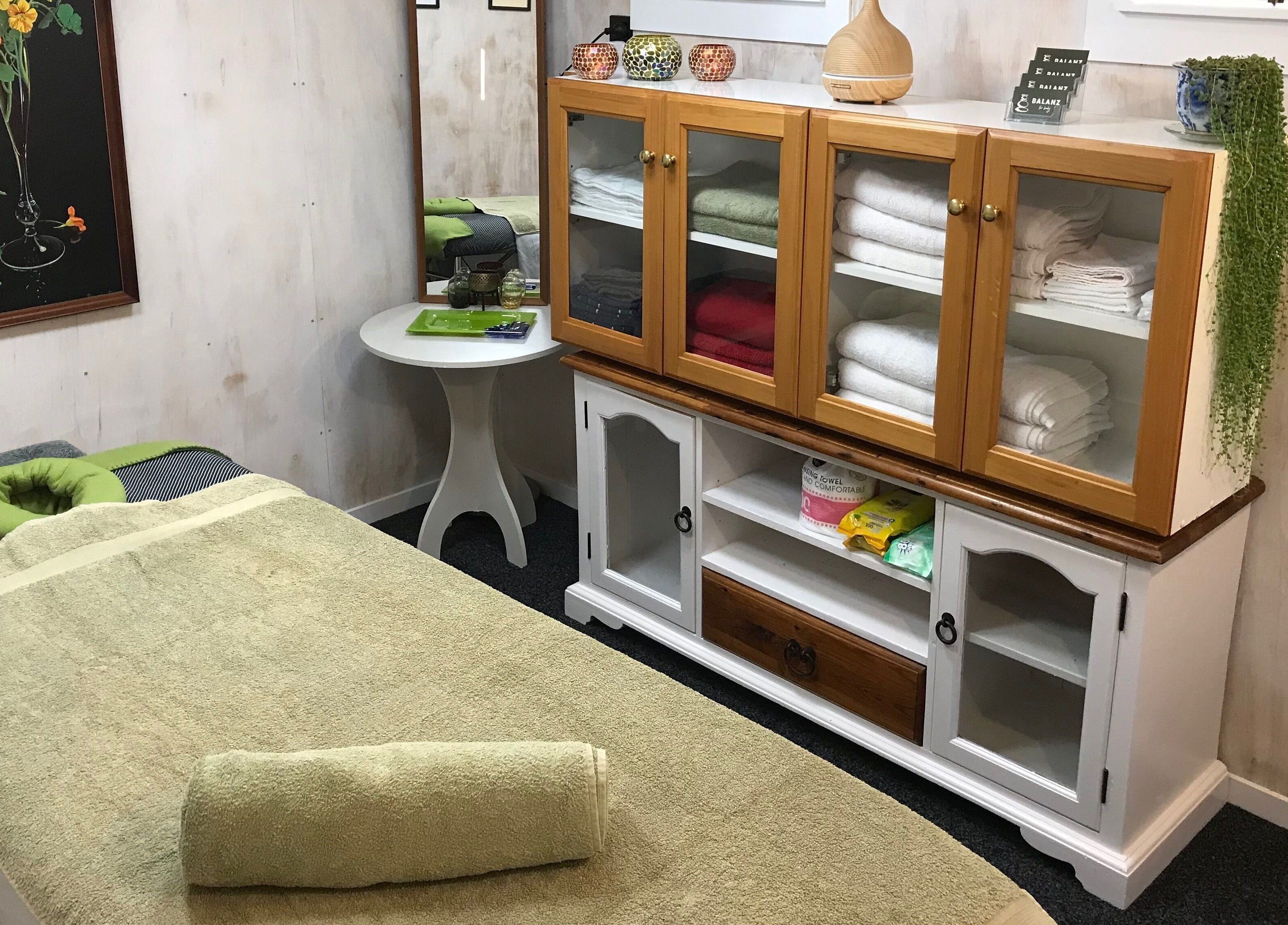 Relaxing massage room at Balanz for Body, Auckland, Auckland, NZ with cozy table and neatly stacked towels.