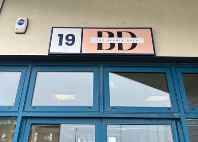 Entrance to The Beauty Deck in Portland, England, GB, featuring blue doors and logo sign.