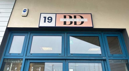 Entrance to The Beauty Deck in Portland, England, GB, featuring blue doors and logo sign.