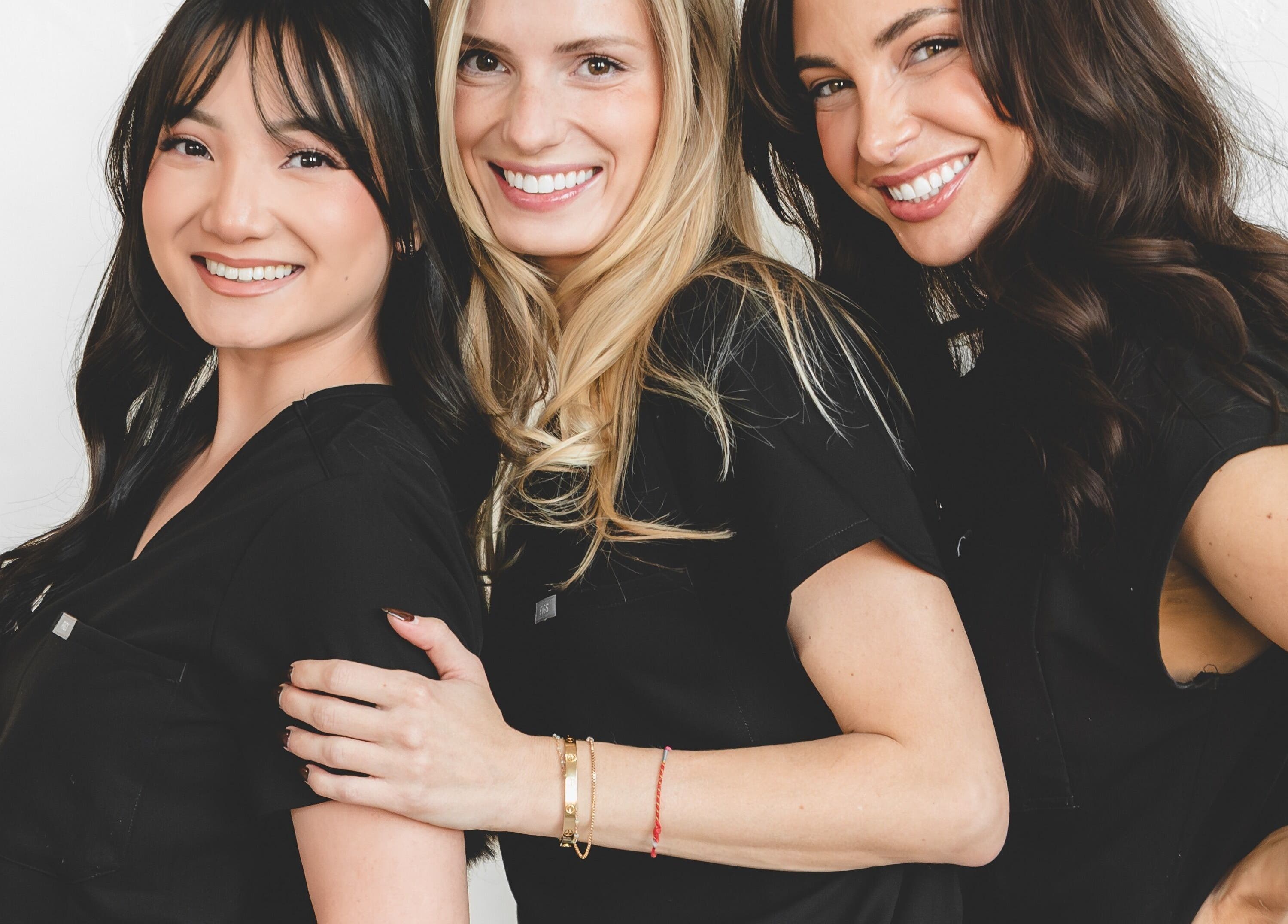 Smiling team of three at Wagner Aesthetic Studio, De Pere, Wisconsin, US, embodying warmth and professionalism.
