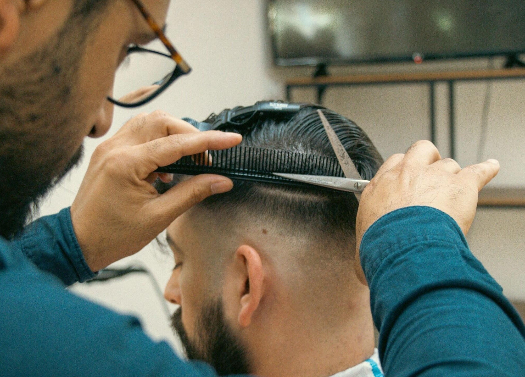 Friseur bei Ali Barber Shop Bern schneidet Haar. Standort: Bern, Bern, CH.