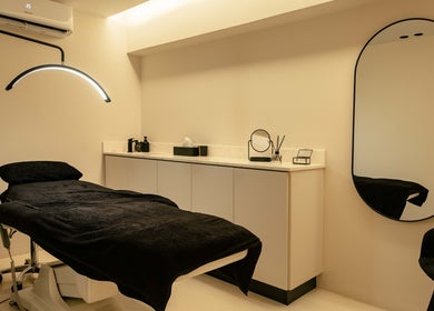 Κομψός χώρος θεραπείας στο Skinu Premium Cosmetics, Αθήνα, GR με καλαίσθητο φωτισμό και άνετη πολυθρόνα.