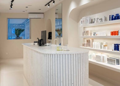 Κομψό εσωτερικό του Skinu Premium Cosmetics στην Αθήνα, GR με προϊόντα ομορφιάς στις ράφια.