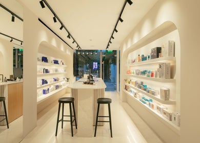 Εσωτερικό του 'Skinu Premium Cosmetics' στην Αθήνα, GR, με κομψά προϊόντα στα ράφια.