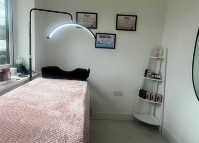 Cozy treatment room at Jordy Lashed Me in Penwortham, England, GB featuring a plush bed and neat display shelves.