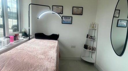 Cozy treatment room at Jordy Lashed Me in Penwortham, England, GB featuring a plush bed and neat display shelves.