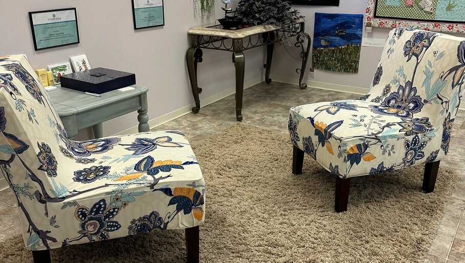 Elegant waiting area at Derma Defined Esthetics in High River, Alberta, CA with floral chairs and cozy decor.