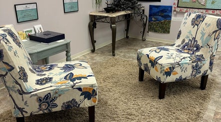 Elegant waiting area at Derma Defined Esthetics in High River, Alberta, CA with floral chairs and cozy decor.