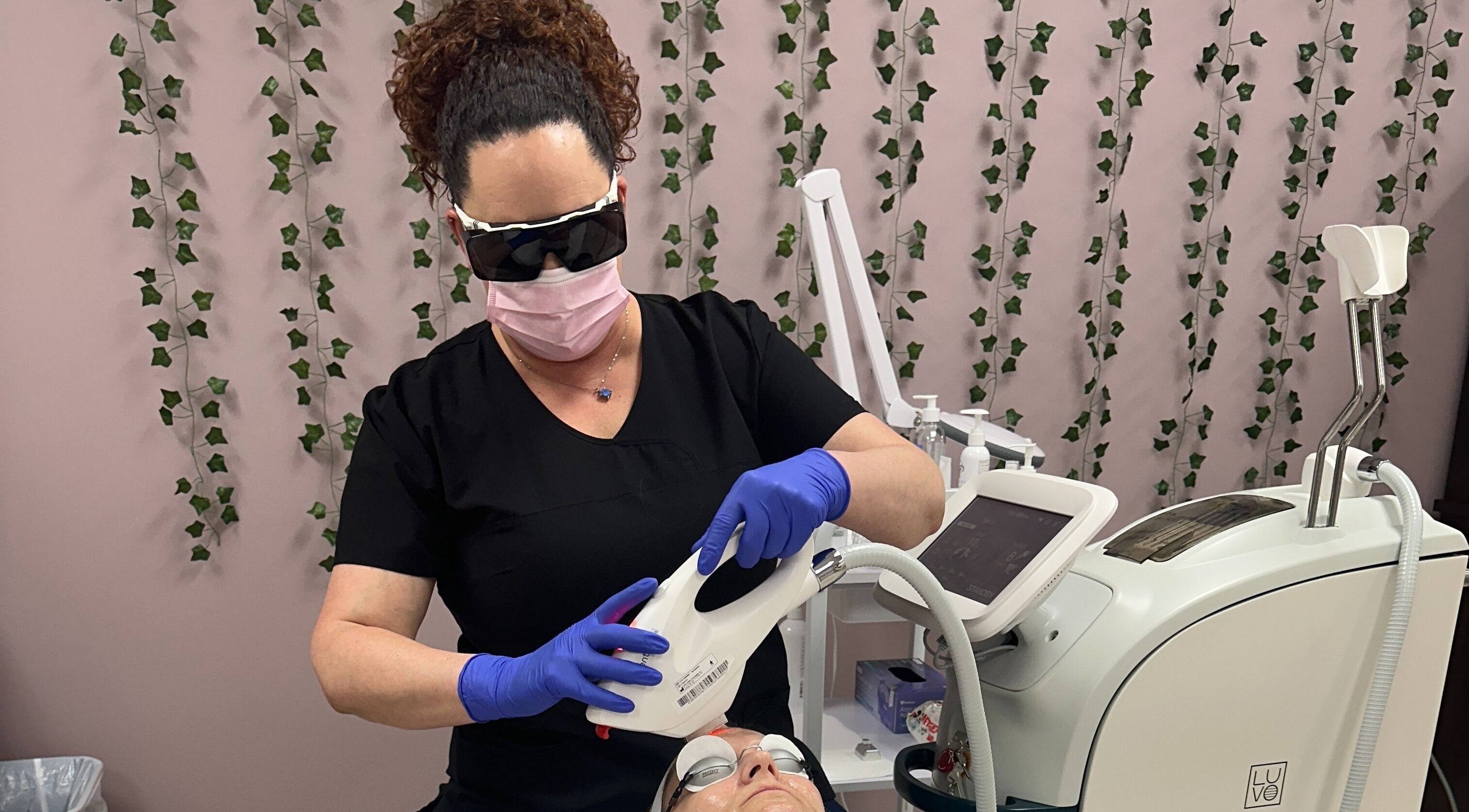 Expert at Derma Defined Esthetics performs skincare treatment in High River, Alberta, CA. Modern equipment visible.