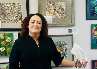 Aesthetician at Derma Defined Esthetics in High River, Alberta, CA, surrounded by vibrant artwork.