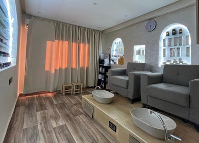 Relaxing pedicure room at Thai London Therapy Marrakesh, Marrakech-safi, MA with plush chairs and ambient lighting.
