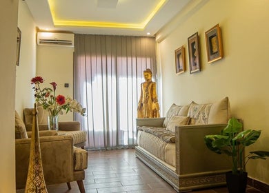 Elegant lounge at Thai London Therapy Marrakesh, Marrakech-safi, MA with plush sofas and golden statue.