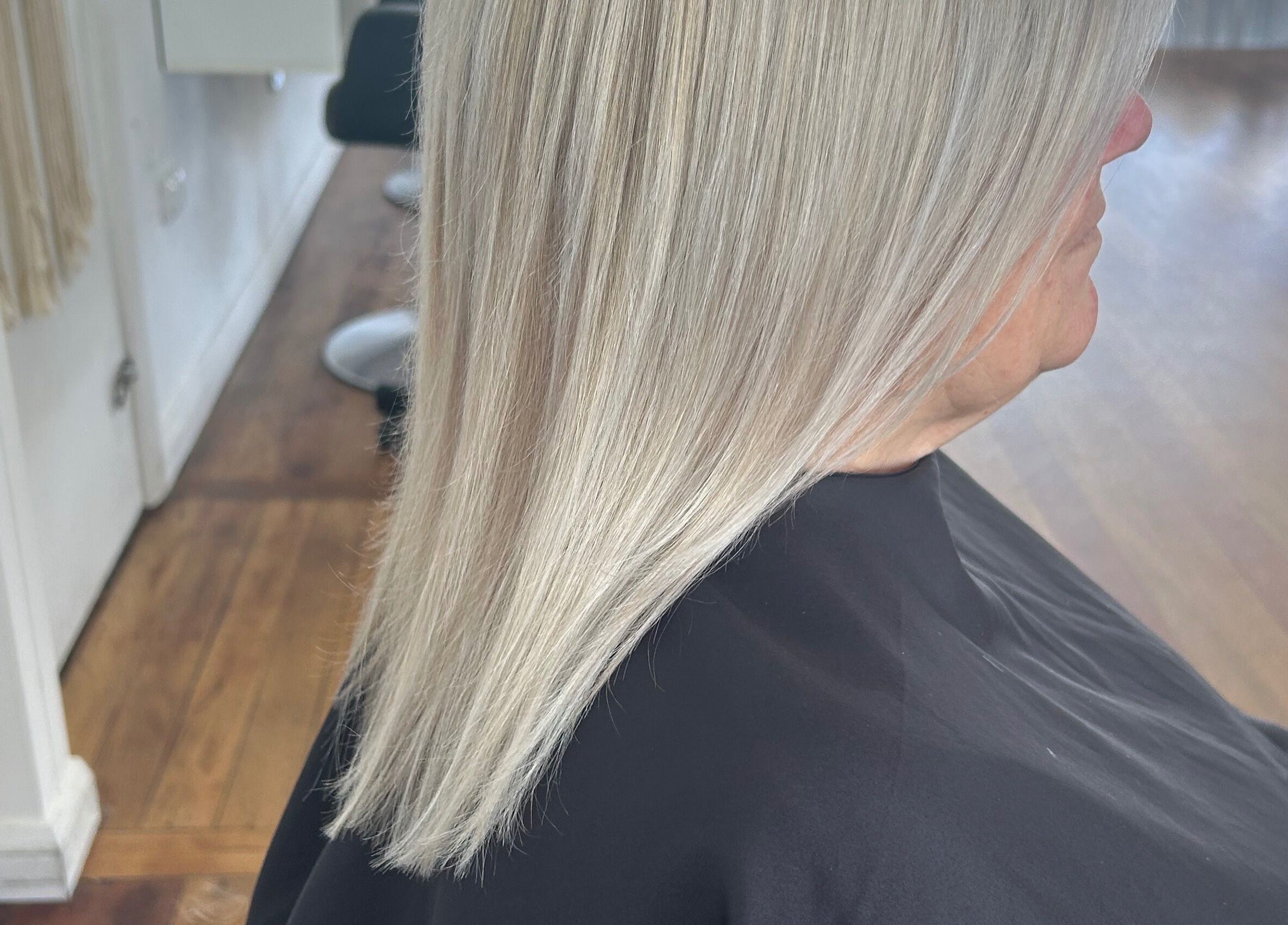 Sleek silver hair styled at Styled by Jess Toohey, Marks Point, New South Wales, AU. Modern salon interior.