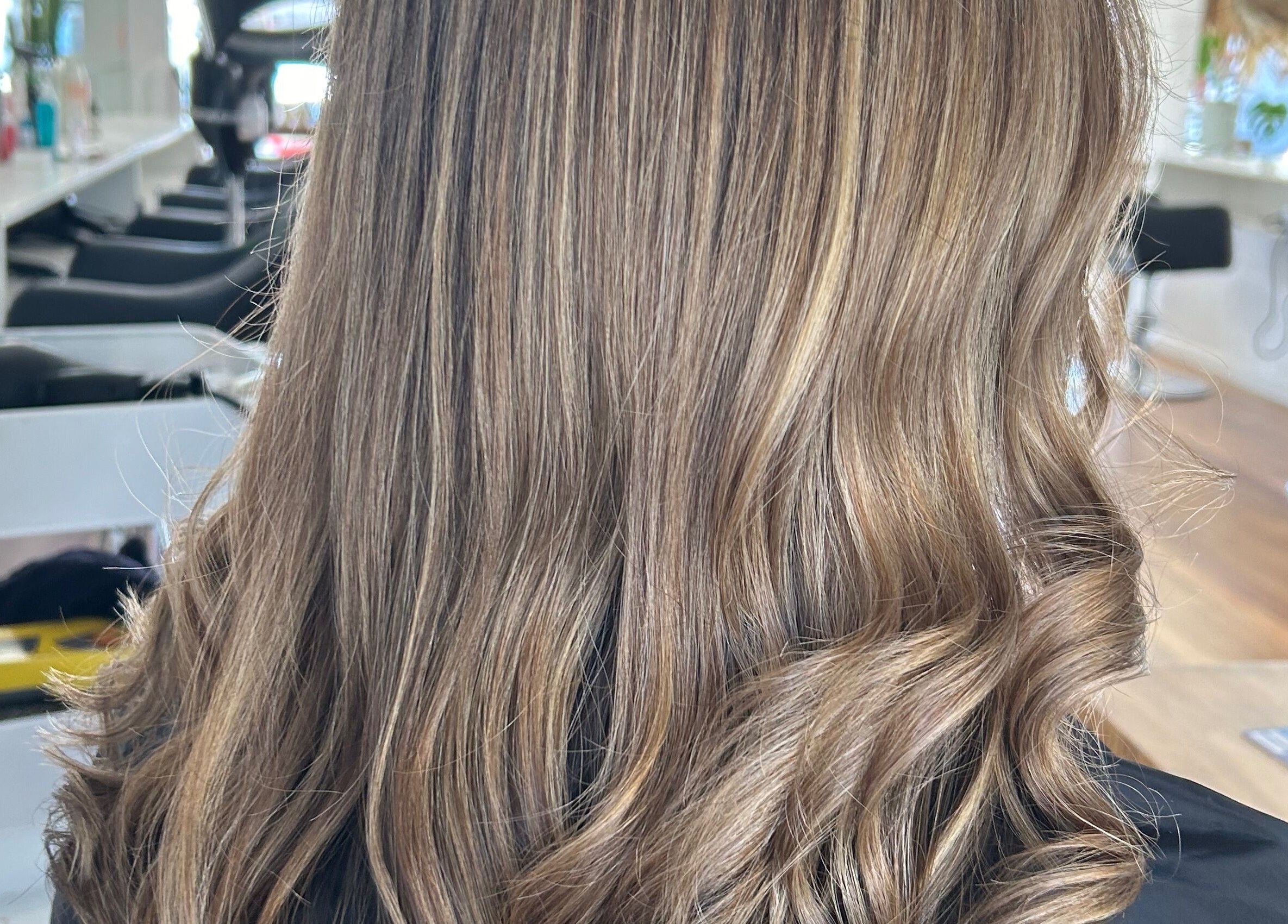 Styled by Jess Toohey salon showcases elegant wavy hairstyle in Marks Point, New South Wales, AU.