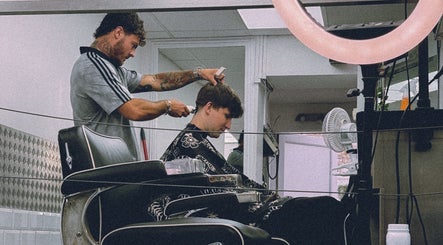 Barber crafting a haircut at Masters Barbershop, Brighton and Hove, England, GB.