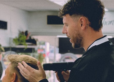 Barber styling hair at Masters Barbershop, Brighton and Hove, England, GB.