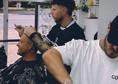 Barber styling a customer's hair at Masters Barbershop, Brighton and Hove, England, GB.