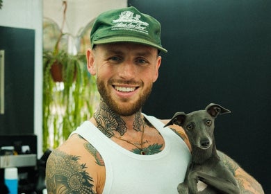 Friendly barber with dog at Masters Barbershop in Brighton and Hove, England, GB.