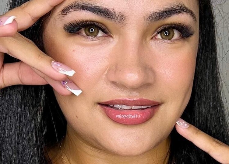 Mujer con pestañas perfectas y uñas decorativas en Lashes Cancún, Cancún, Quintana Roo, MX.