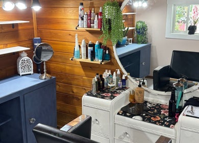 Cozy styling area at Hot on Top Salon, Regina, Saskatchewan, CA with wooden walls and beauty products.