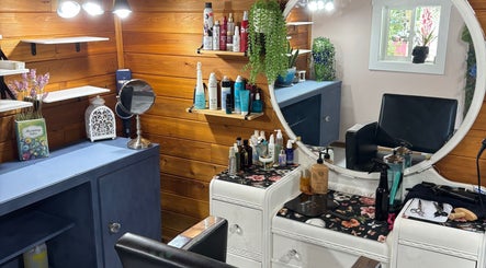 Cozy styling area at Hot on Top Salon, Regina, Saskatchewan, CA with wooden walls and beauty products.