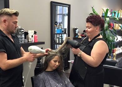 Hair stylists at Hot on Top Salon in Regina, Saskatchewan, CA expertly blow-drying a client's hair.