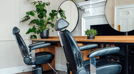Modern salon chairs and round mirror at Thea Hair Rendezvous, London, England, GB.