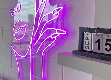 Vibrant purple neon sign and calendar at Jrbeautylab, London, England, GB, creating a modern ambiance.