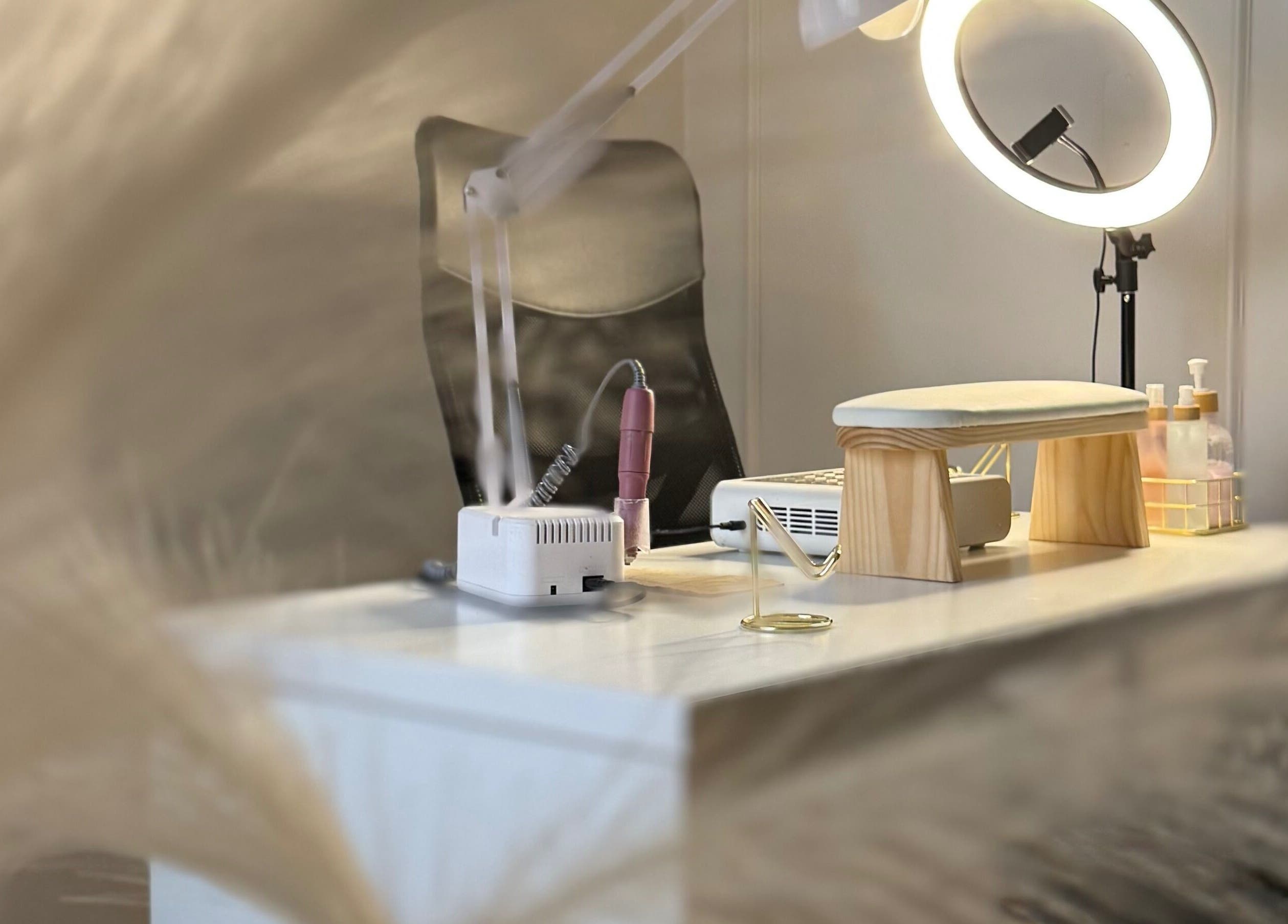 Mesa de manicura en Carla Manicure CL, Ñuñoa, Región Metropolitana, CL, con lámpara y productos.