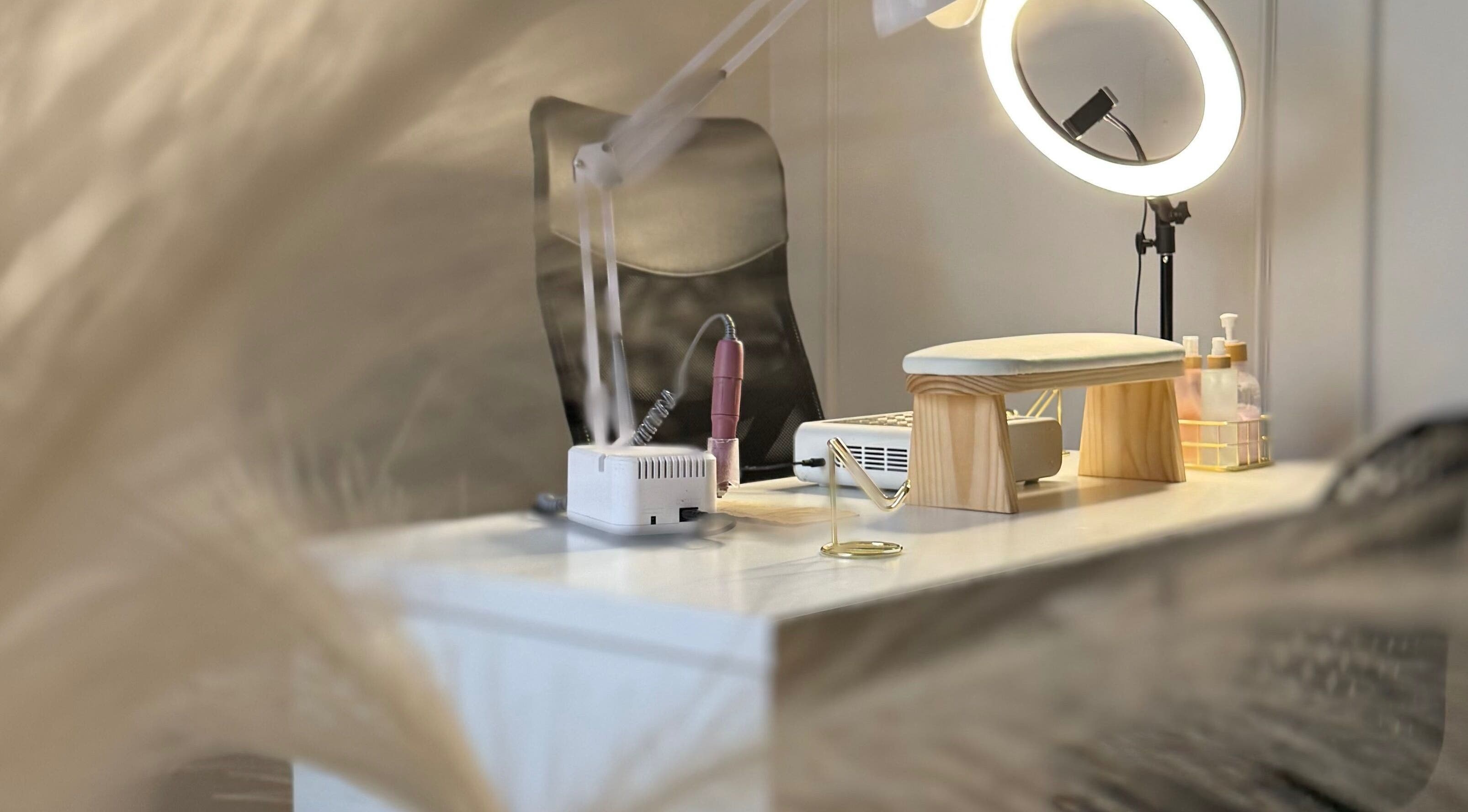 Mesa de manicura en Carla Manicure CL, Ñuñoa, Región Metropolitana, CL, con lámpara y productos.