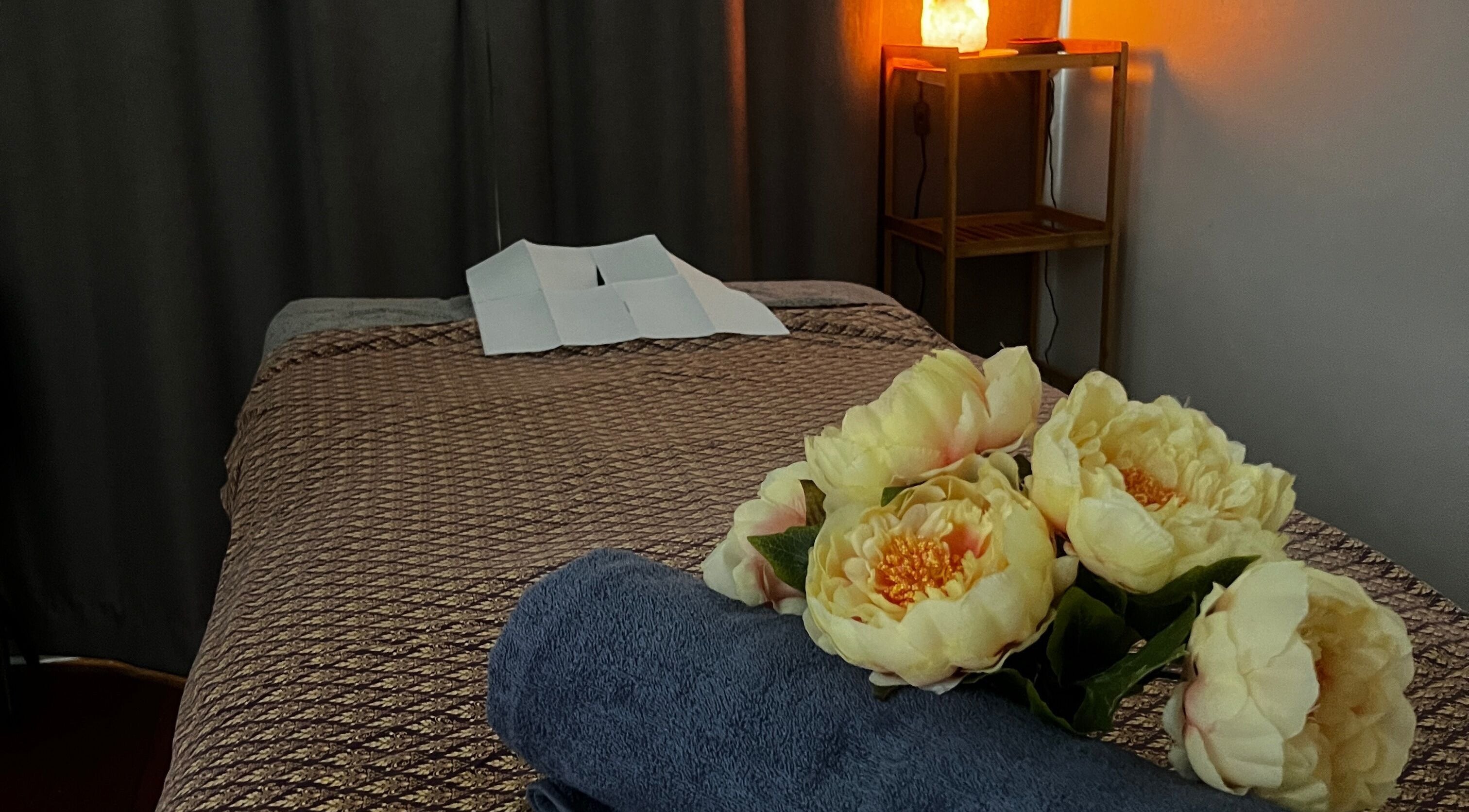 Relaxing massage table with flowers at Fern Spa & Massage, Auckland, Auckland, NZ, offering tranquility.