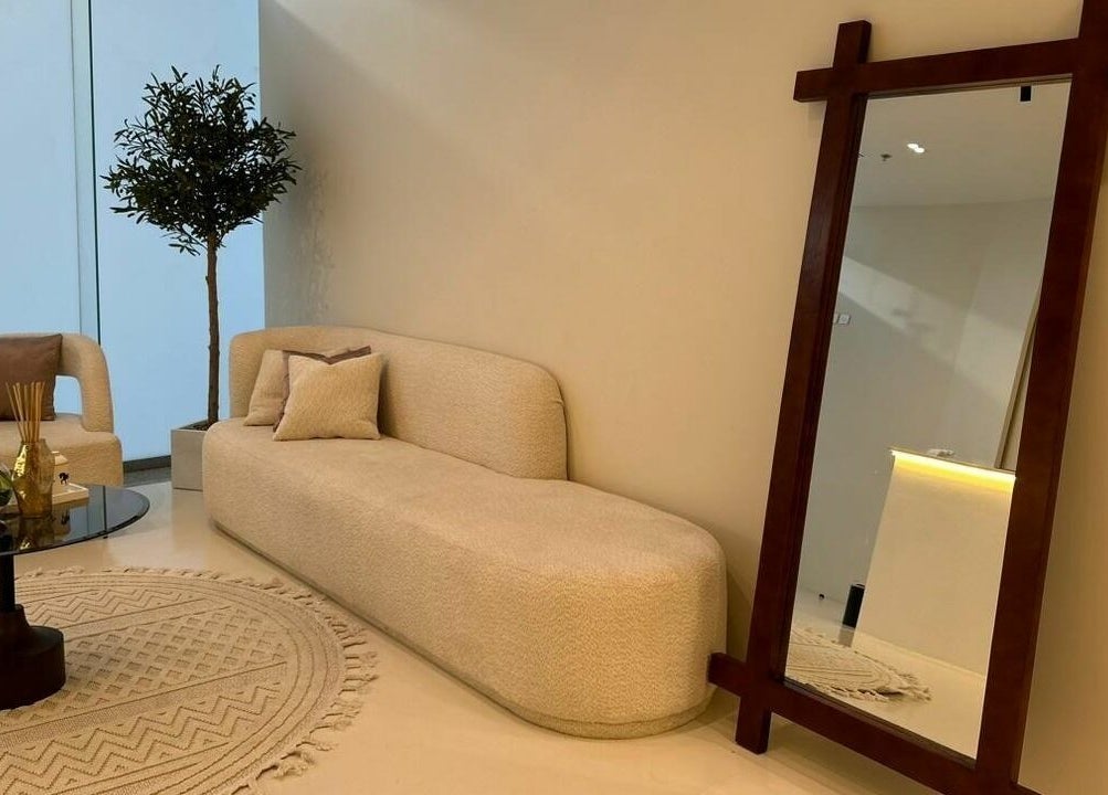 Elegant seating area at Noor Beauty Salon, Dammam, Eastern Province, SA featuring plush couch and mirror.