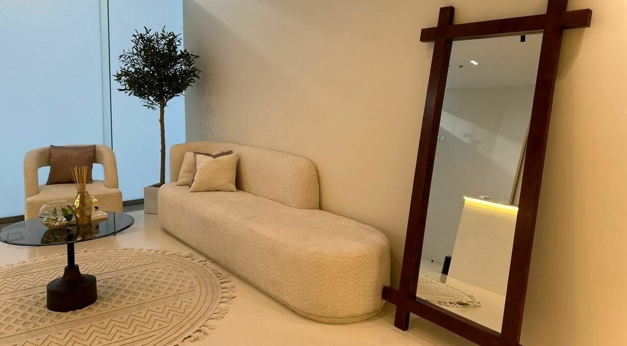 Elegant seating area at Noor Beauty Salon, Dammam, Eastern Province, SA featuring plush couch and mirror.