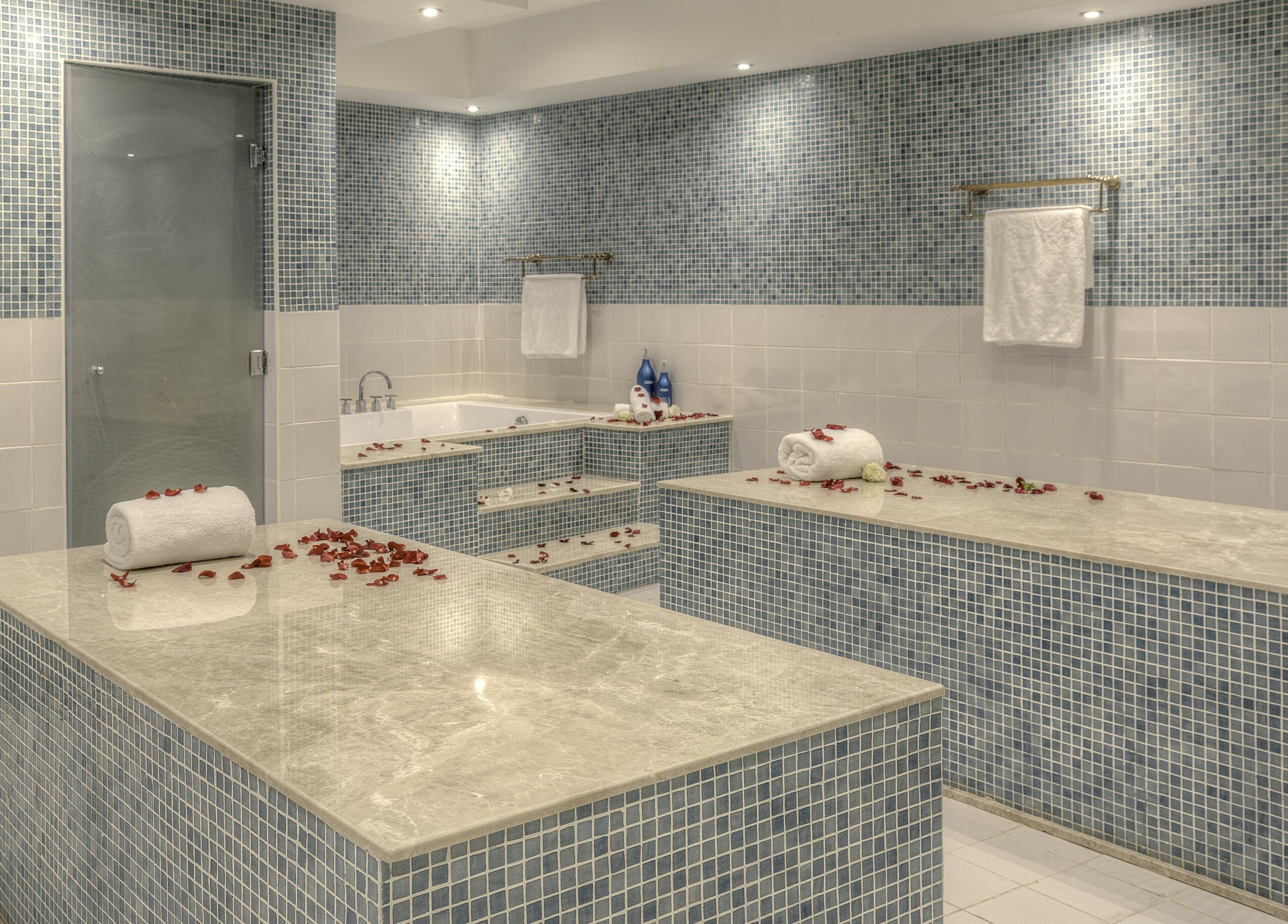 Luxurious spa room at Pout Salon and Spa, Dubai, AE with marble countertops and rose petals for relaxation.
