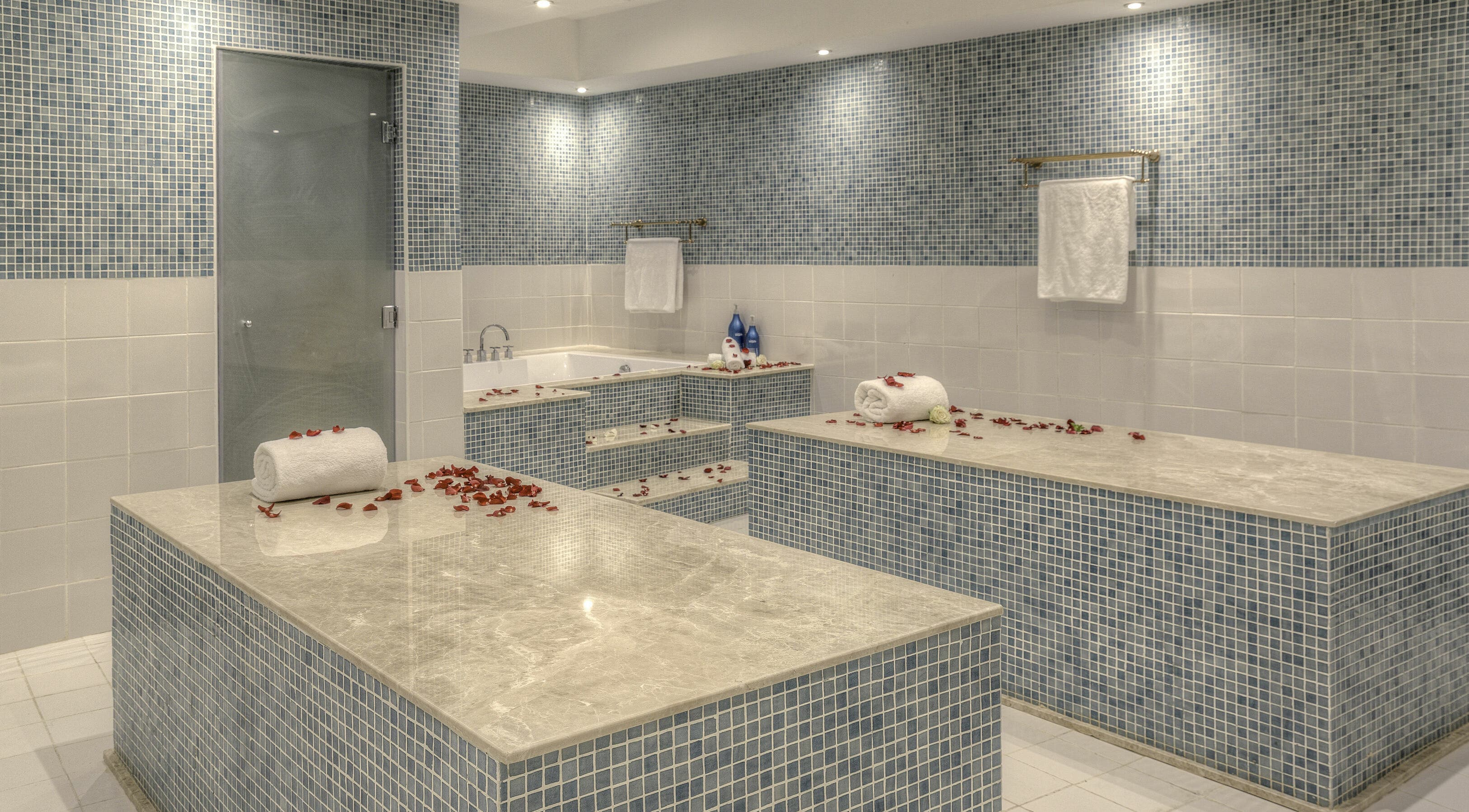 Luxurious spa room at Pout Salon and Spa, Dubai, AE with marble countertops and rose petals for relaxation.