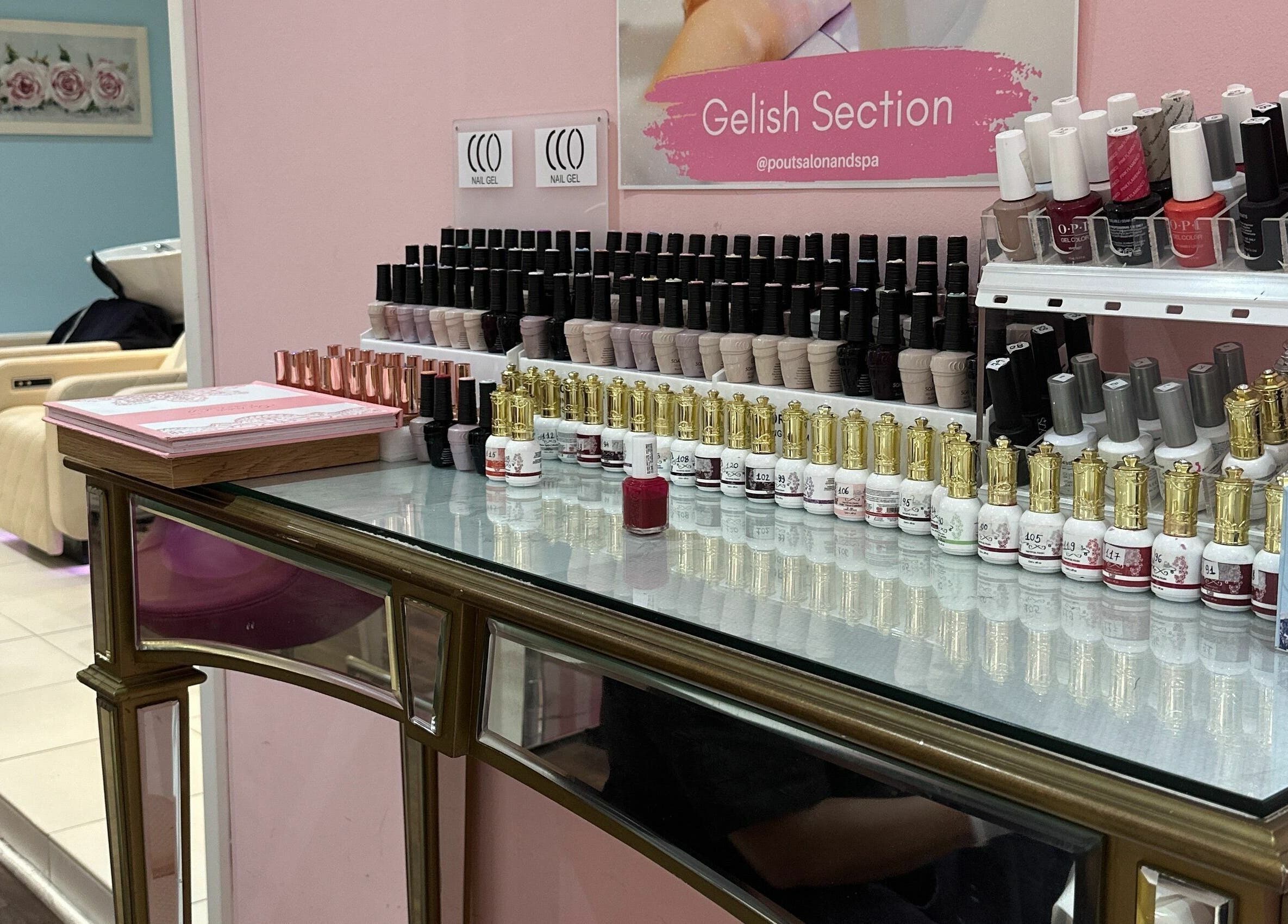 Nail polish collection displayed at Pout Salon and Spa, Dubai, AE, showcasing diverse colors and styles.
