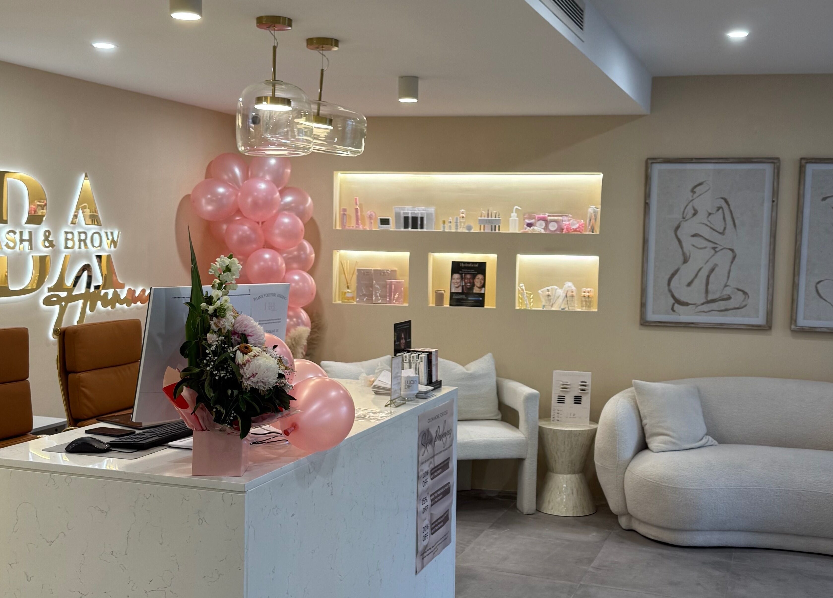 Chic reception area at Lash and Brow Avenue - Liverpool, featuring cozy seating and pink decor in New South Wales, AU.