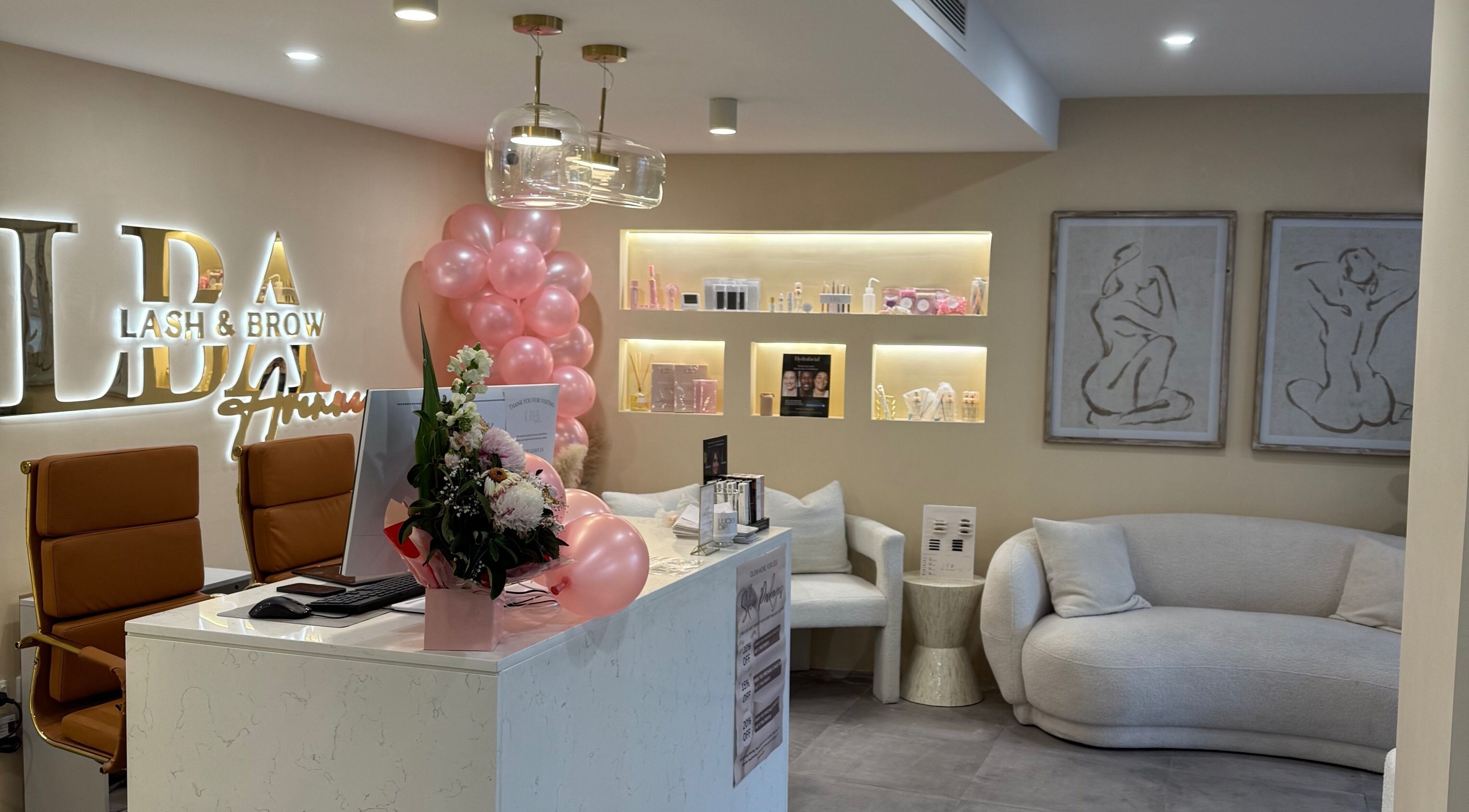 Chic reception area at Lash and Brow Avenue - Liverpool, featuring cozy seating and pink decor in New South Wales, AU.