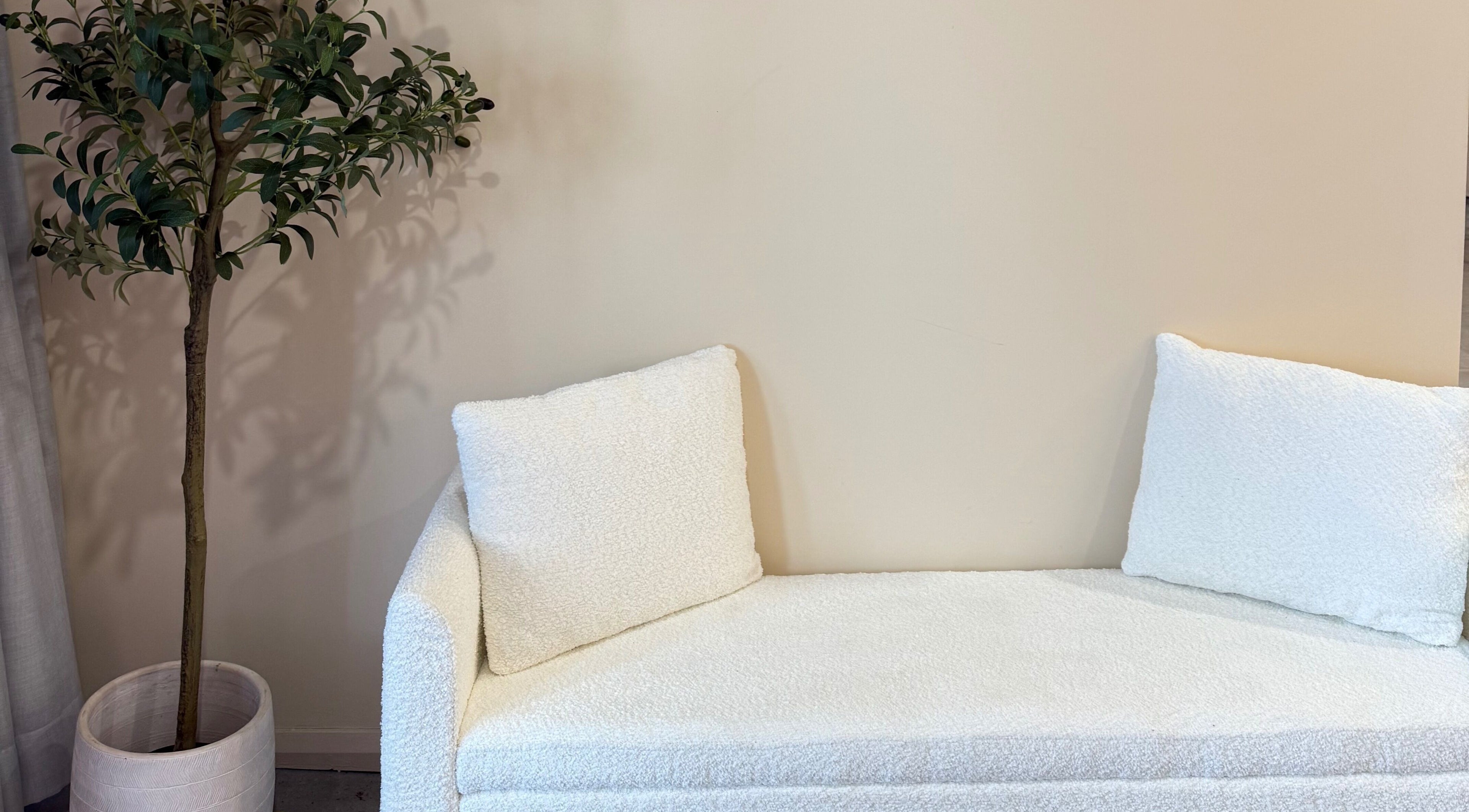 Cozy white couch beside a potted plant at Lash and Brow Avenue - Liverpool, New South Wales, AU.