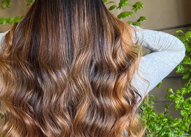 Flowing wavy hair transformation at Cpt Hairn, Cape Town, Western Cape, ZA, embraced by green plants.