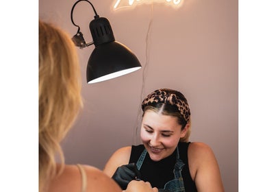 Manicurist at Maisy Does Manis in Shrewsbury, England, providing expert service under warm lighting.