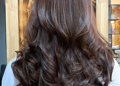 Elegant wavy hairstyle at VIP Healthy Hair in Muang Pattaya, Chon Buri, TH. Vibrant brown curls shine brilliantly.