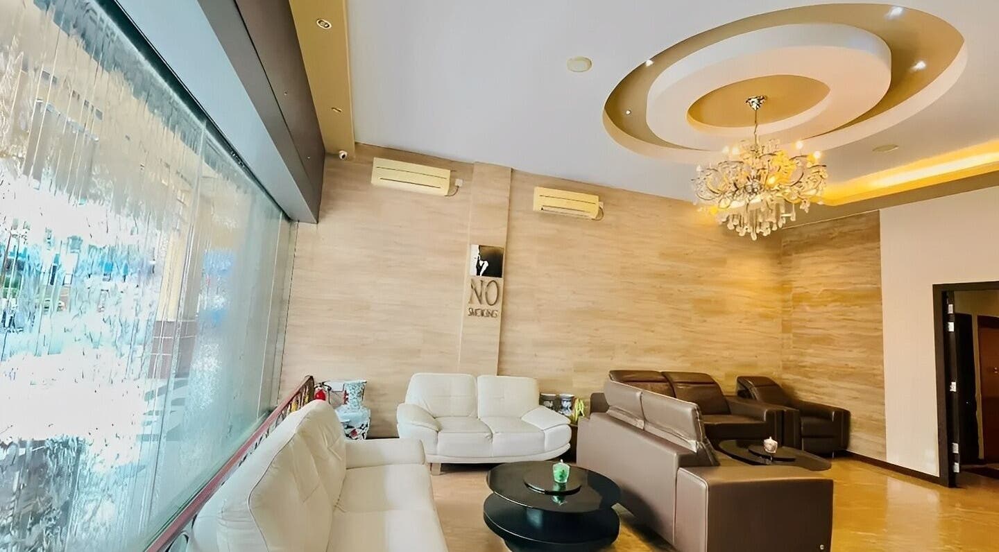 Elegant lounge area at Grand Majesty Day Spa, Batam, ID showcasing plush seating and a chandelier.