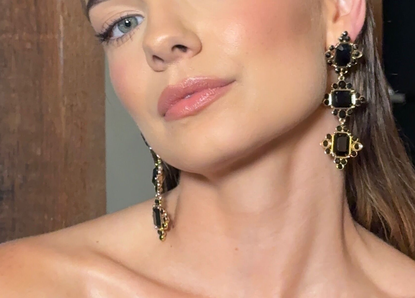 Close-up of a woman's radiant face showcasing elegant earrings at Faces By Jana, Melbourne, Victoria, AU.