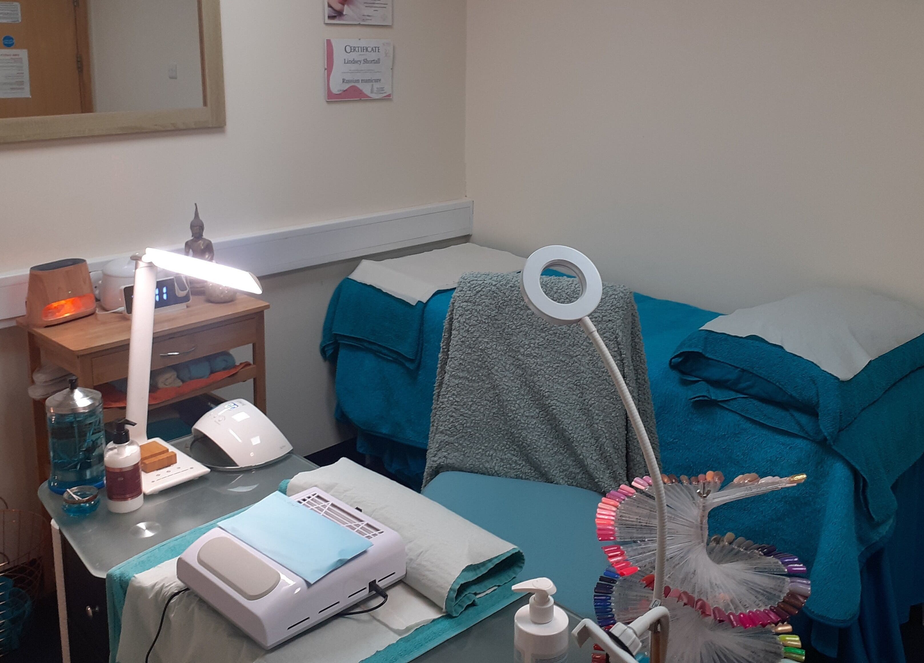 Cozy treatment room at The Nook, Ellesmere Port, England, GB, featuring plush towels and calming décor.