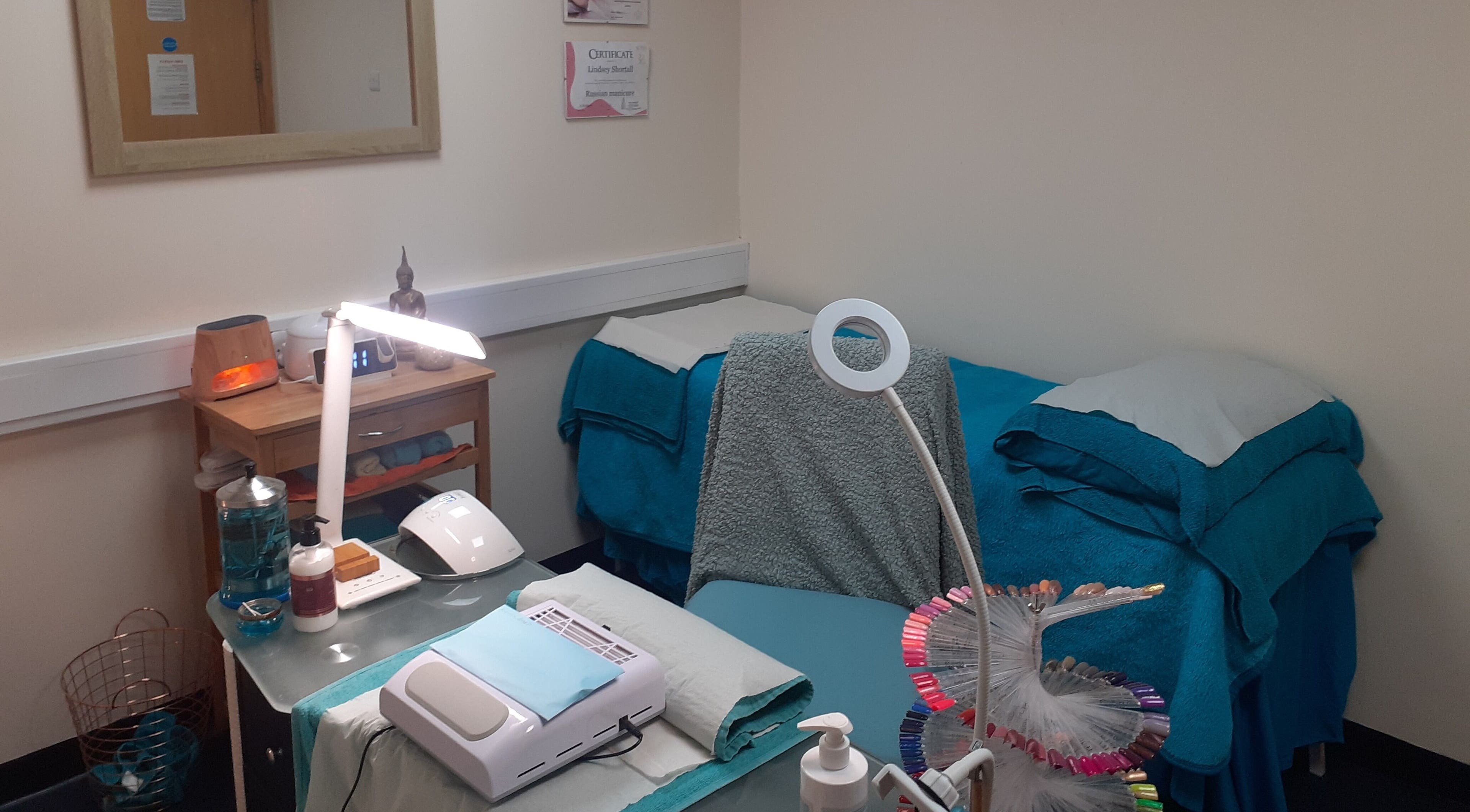 Cozy treatment room at The Nook, Ellesmere Port, England, GB, featuring plush towels and calming décor.