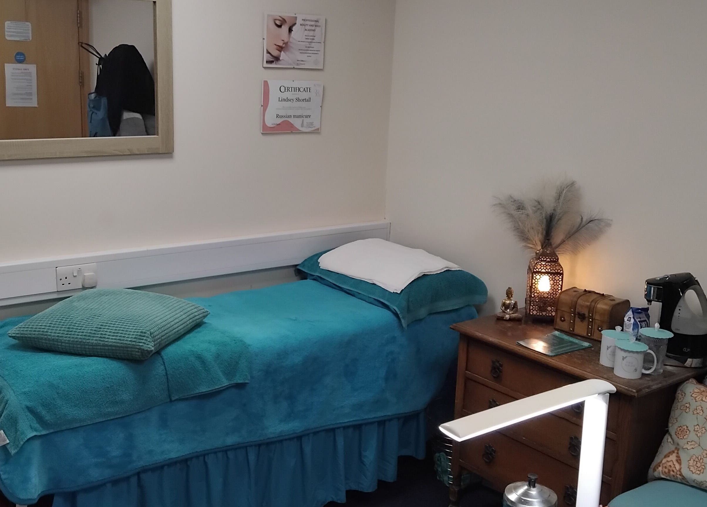 Cozy massage room at The Nook, Ellesmere Port, England, GB with blue decor and wooden furniture.