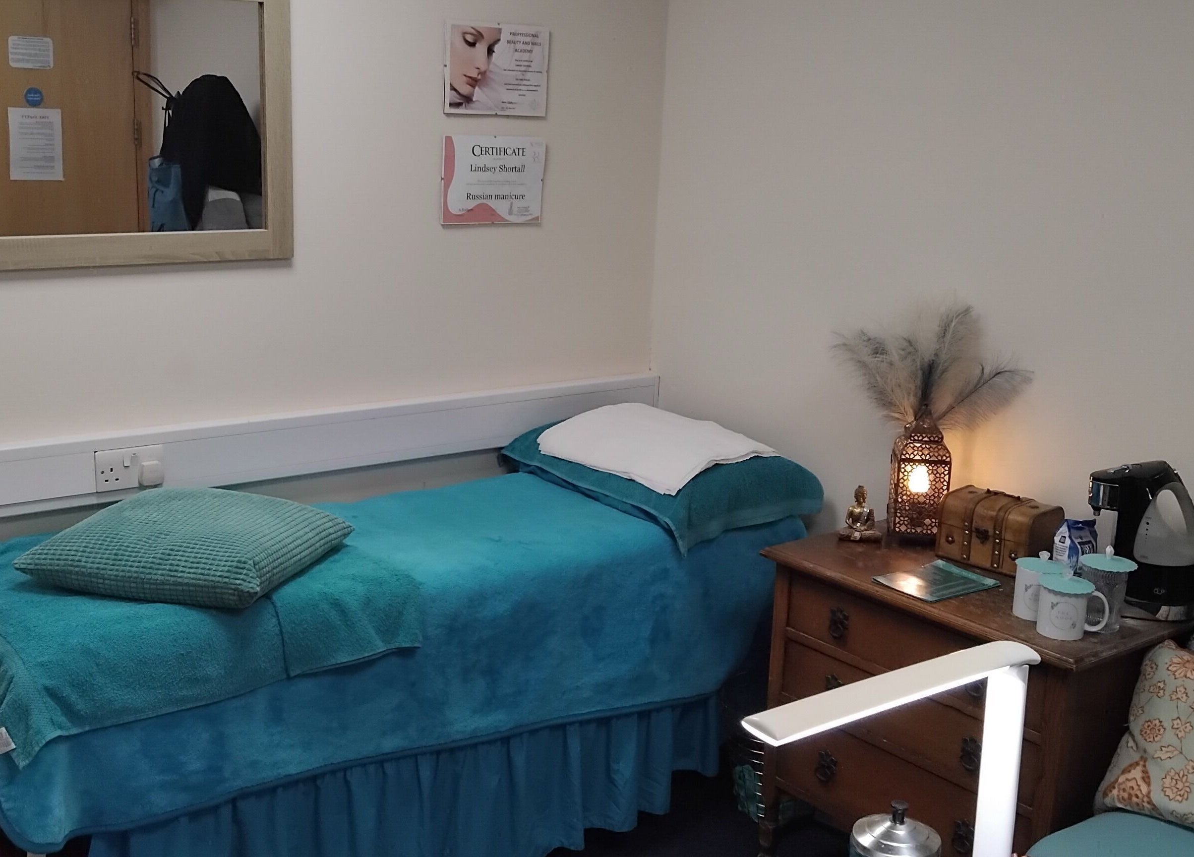 Cozy massage room at The Nook, Ellesmere Port, England, GB with blue decor and wooden furniture.